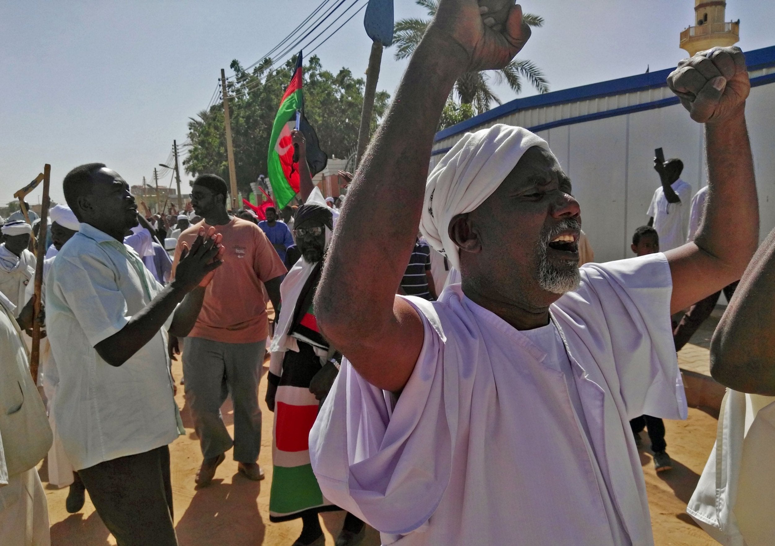 Sudanese men shout slogans during an anti-government protest following Friday noon prayers on 18 January 2019