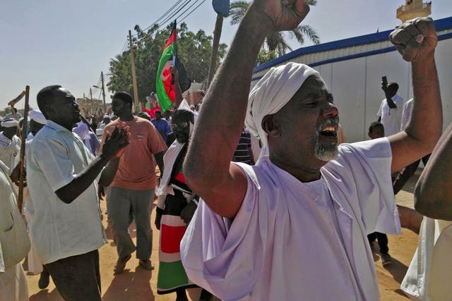 Sudanese men shout slogans during an anti-government protest following Friday noon prayers on 18 January 2019