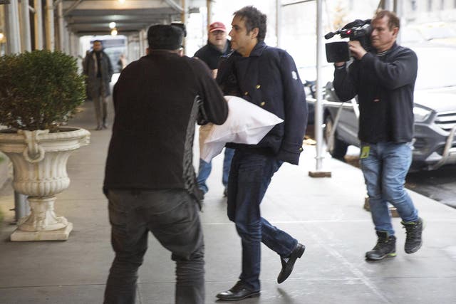 Michael Cohen arrives at his home in New York with his left arm in a sling supported by a pillow