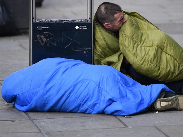Men in sleeping bags lie on the ground in London