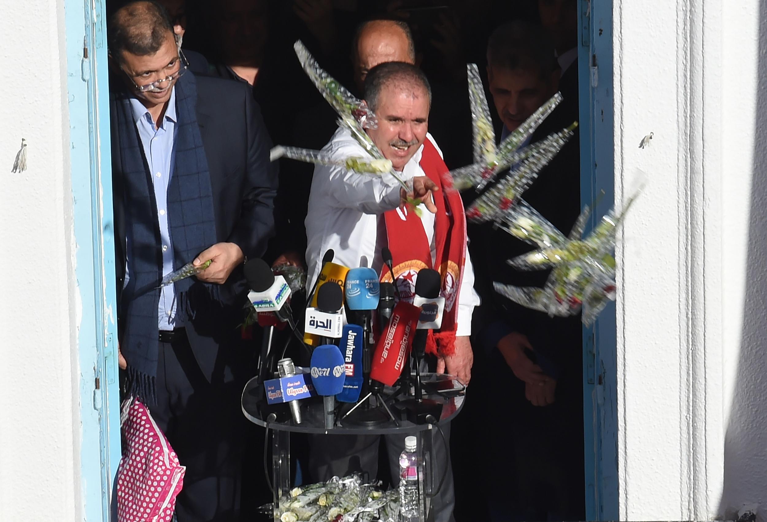 Union leader Noureddine Taboubi throws flowers at workers before his speech (AFP/Getty)