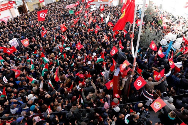 Tunisian workers gather in front of the national union headquarters in the capital Tunis on Thursday