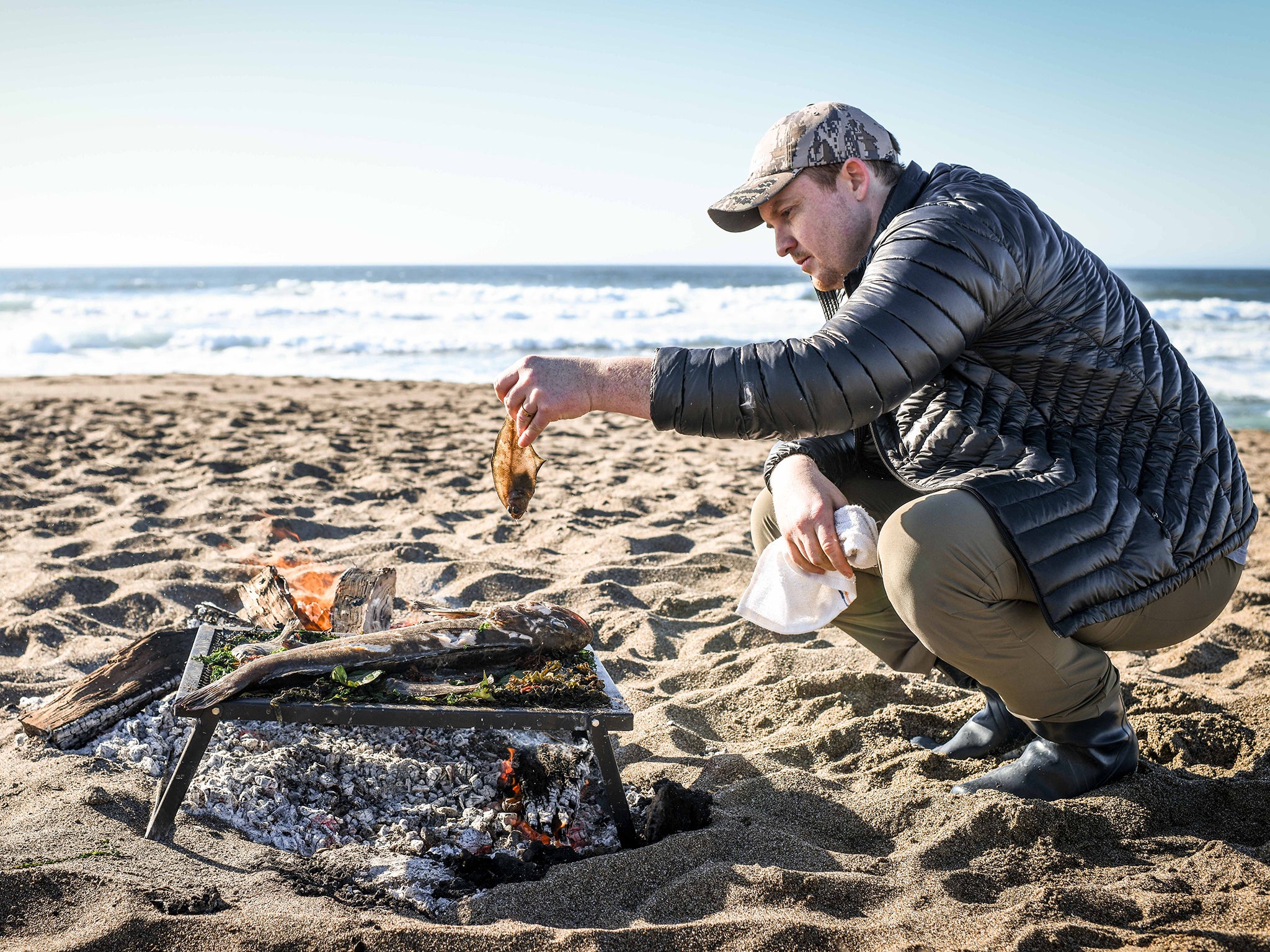 Skenes preparing his latest catch on the beach