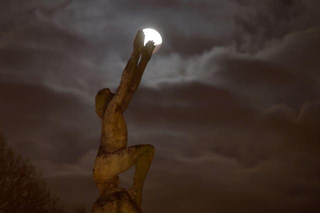 A picture taken on January 21, 2019 in Le Mans northwestern France shows the Super Blood Moon during a lunar eclipse behind the statue named "L'envol"
