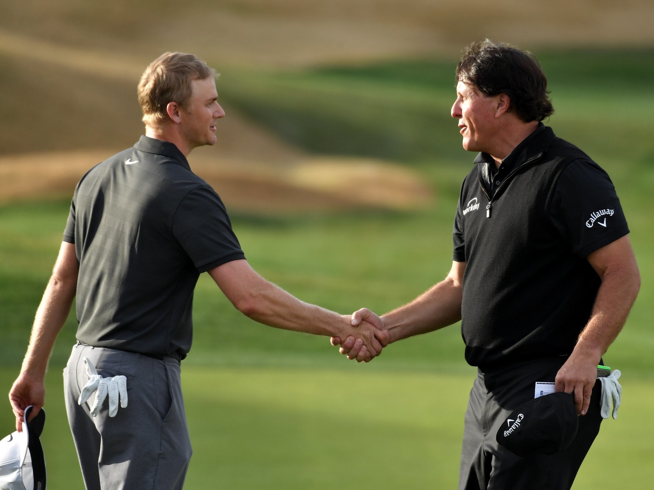 Adam Long and Phil Mickelson embrace after the former wins the Desert Classic