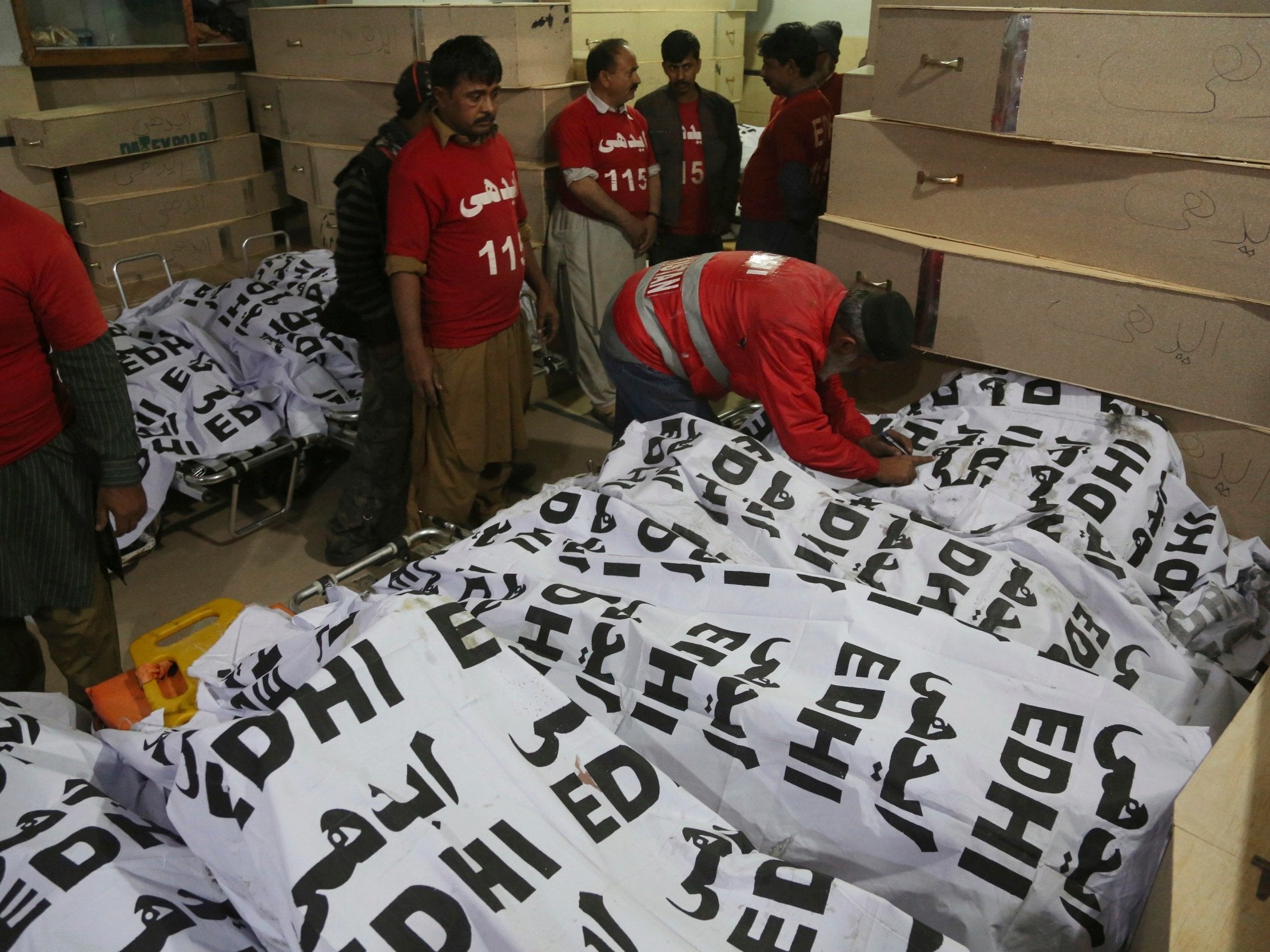 Pakistan volunteers arrange bodies of passengers killed when a bus burst into flames after colliding with an oil tanker in 
in Karachi, Pakistan, on 22 January, 2019.