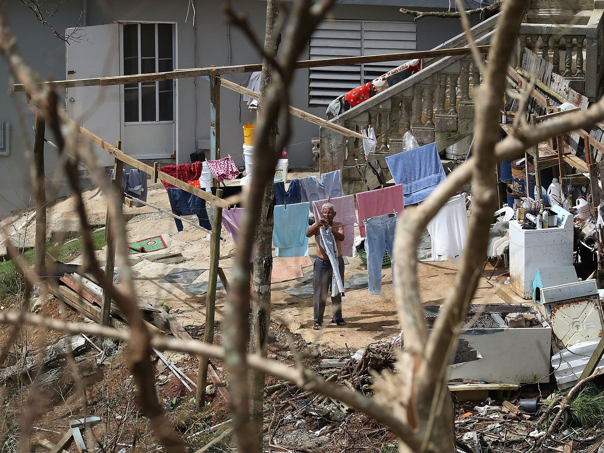 A man hangs laundry up as people wait for the electrical grid to be repaired in September 2017 in Progreso Barrio Pulguillas (Getty)