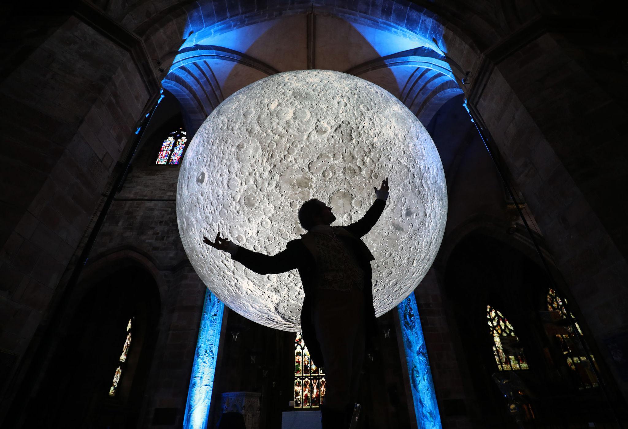 Actor Gareth Morrison gets into character as Rabbie Burns underneath the Museum of the Moon installation in St Giles' Cathedral, Edinburgh, during the launch of the Burns & Beyond Festival