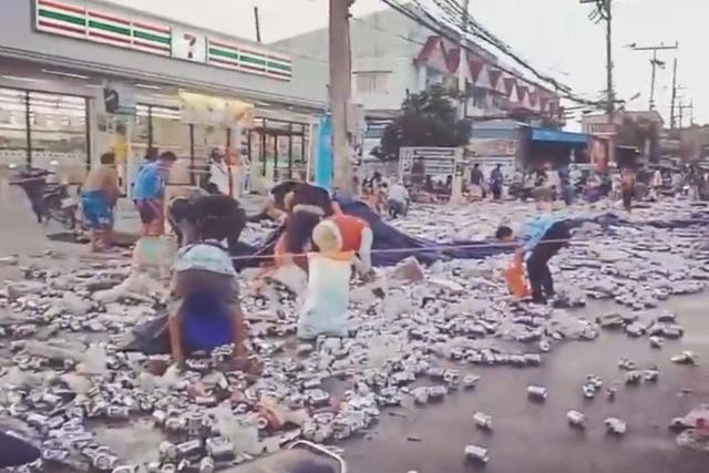 Video footage captured locals gathering up beer cans after a lorry overturned in Phuket, Thailand