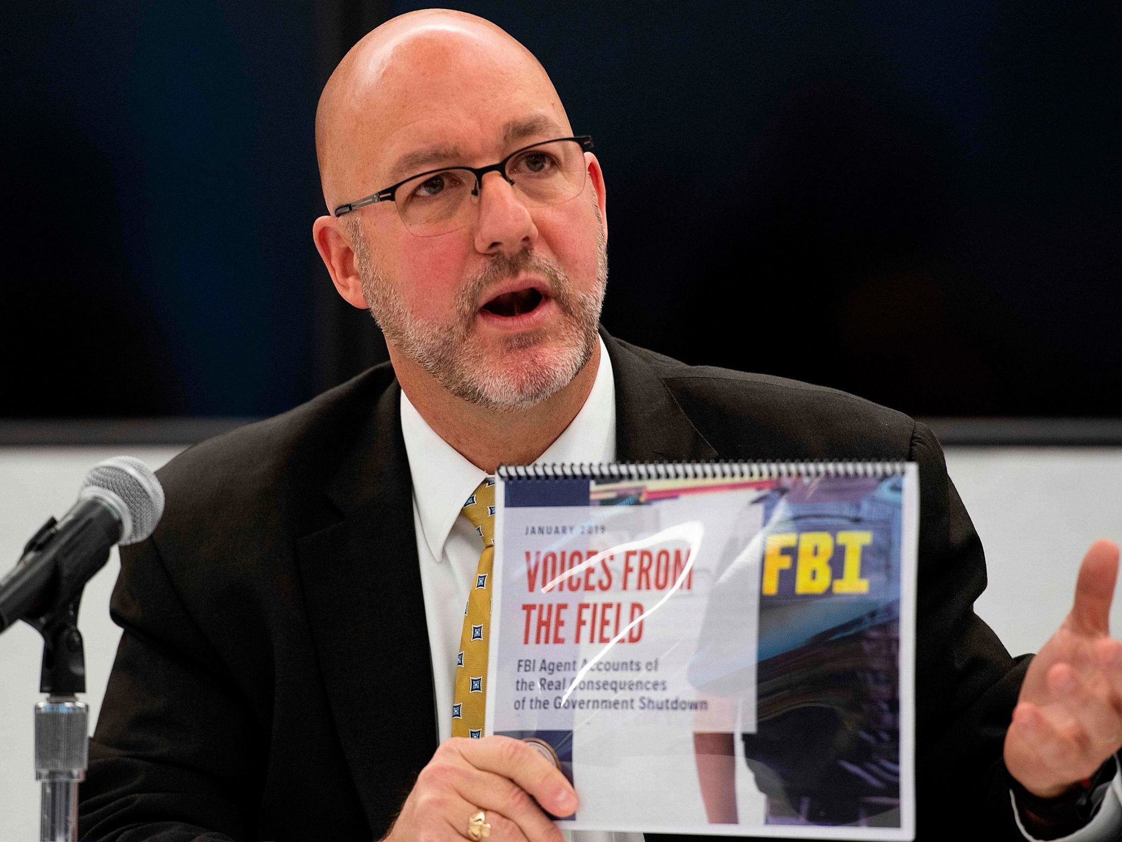 FBI Agents Association’s Thomas O’Connor holds up an FBI report ‘Voices From the Field’ giving examples of how the government shutdown is undermining its work (Getty)