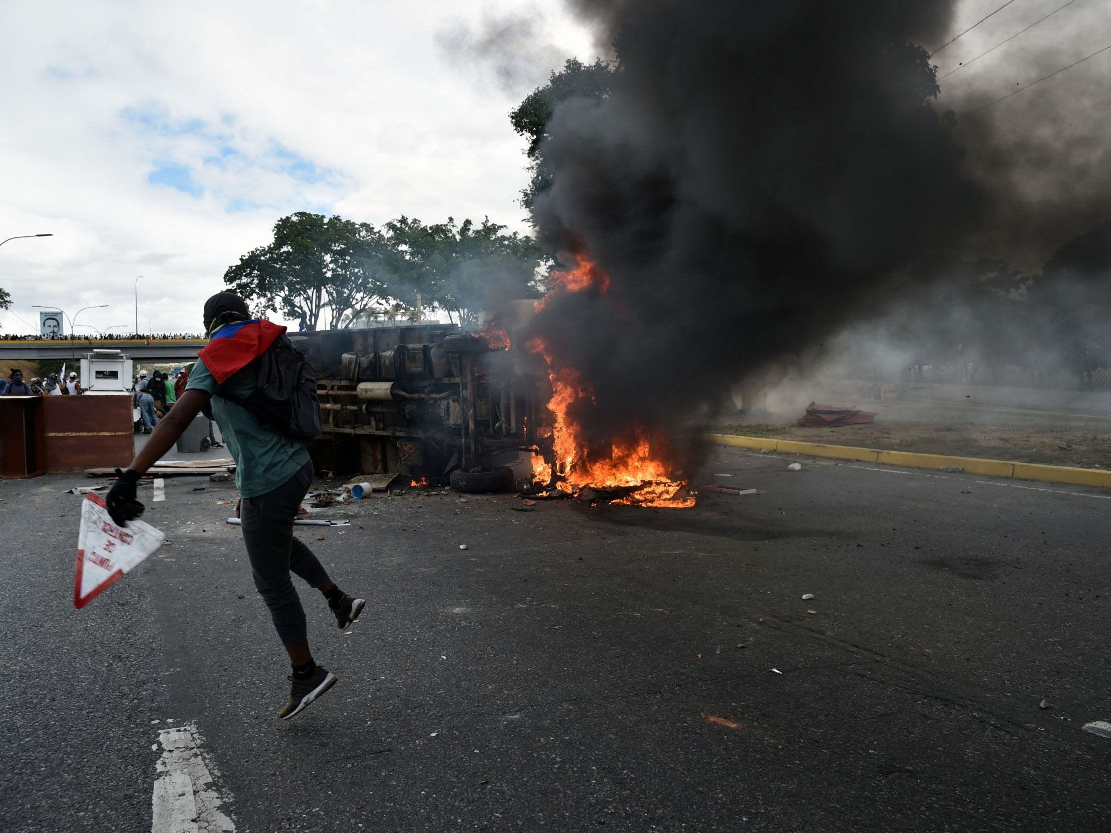 A vehicle is set on fire by Venezuelan opposition demonstrators, during a protest against the government of President Nicolas Maduro, on the anniversary of 1958 uprising that overthrew military dictatorship in Caracas on 23 January 2019
