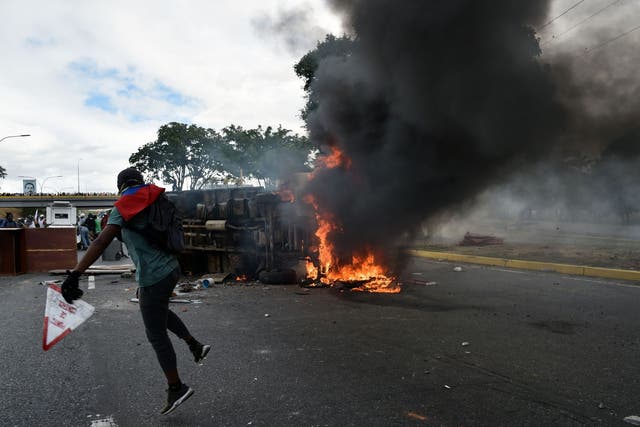 A vehicle is set on fire by Venezuelan opposition demonstrators, during a protest against the government of President Nicolas Maduro, on the anniversary of 1958 uprising that overthrew military dictatorship in Caracas on 23 January 2019