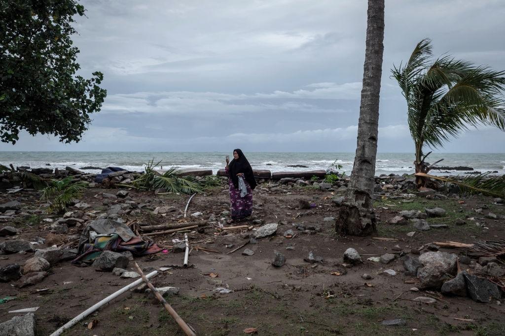 A woman taking pictures of debris with her smartphone on 24 December, 2018 in Carita, Indonesia. Over 280 people were reportedly  killed after a volcano-triggered tsunami hit the coast around Indonesia's Sunda Strait