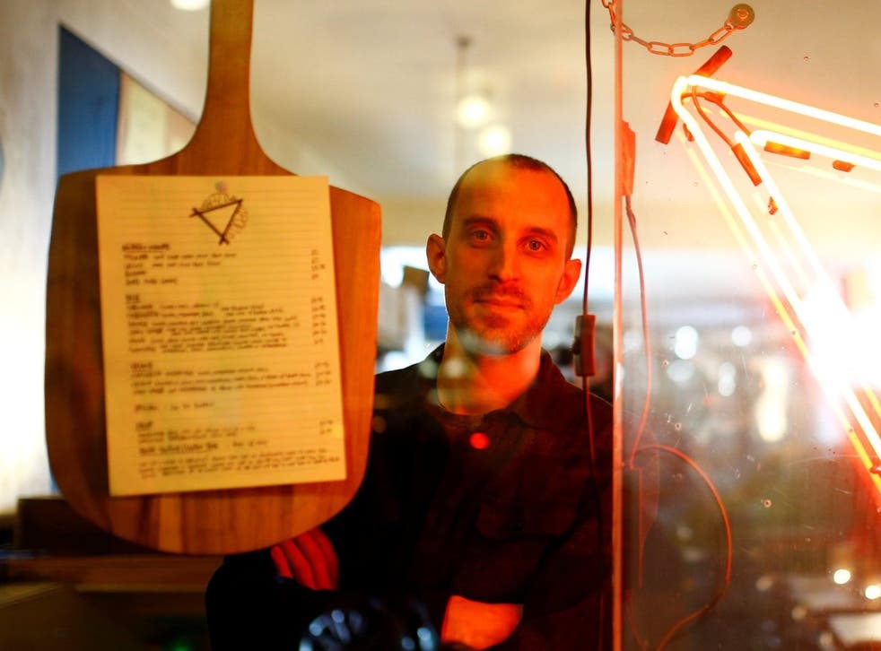 Oliver Kenny, the owner of Apollo Pizzeria, poses at his restaurant in London