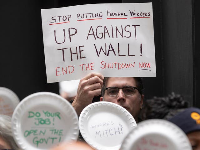 A man holds a sign during a protest at the Hart Senate in Washington, DC, against the partial US government shutdown.