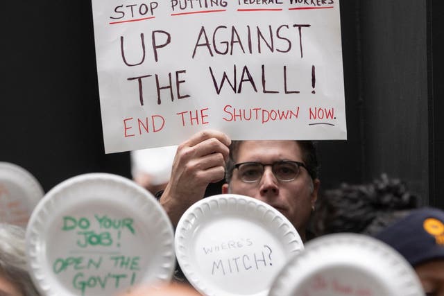 A man holds a sign during a protest at the Hart Senate in Washington, DC, against the partial US government shutdown.