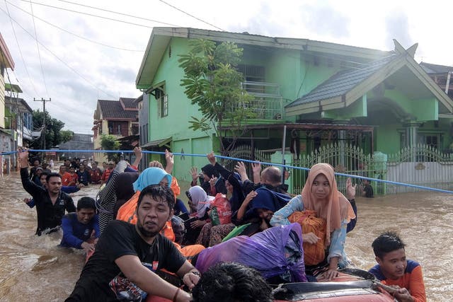 Residents evacuate their homes in Makassar, Indonesia, after heavy rain and strong winds pounded the southern part of Sulawesi island, swelling rivers that burst their banks.