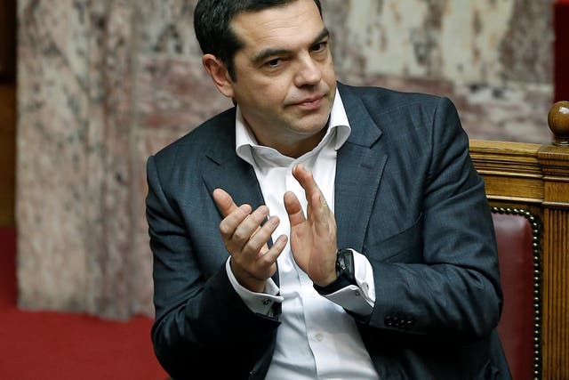 Greek Prime Minister Alexis Tsipras applauds during a parliament session before a vote on an accord between Greece and Macedonia