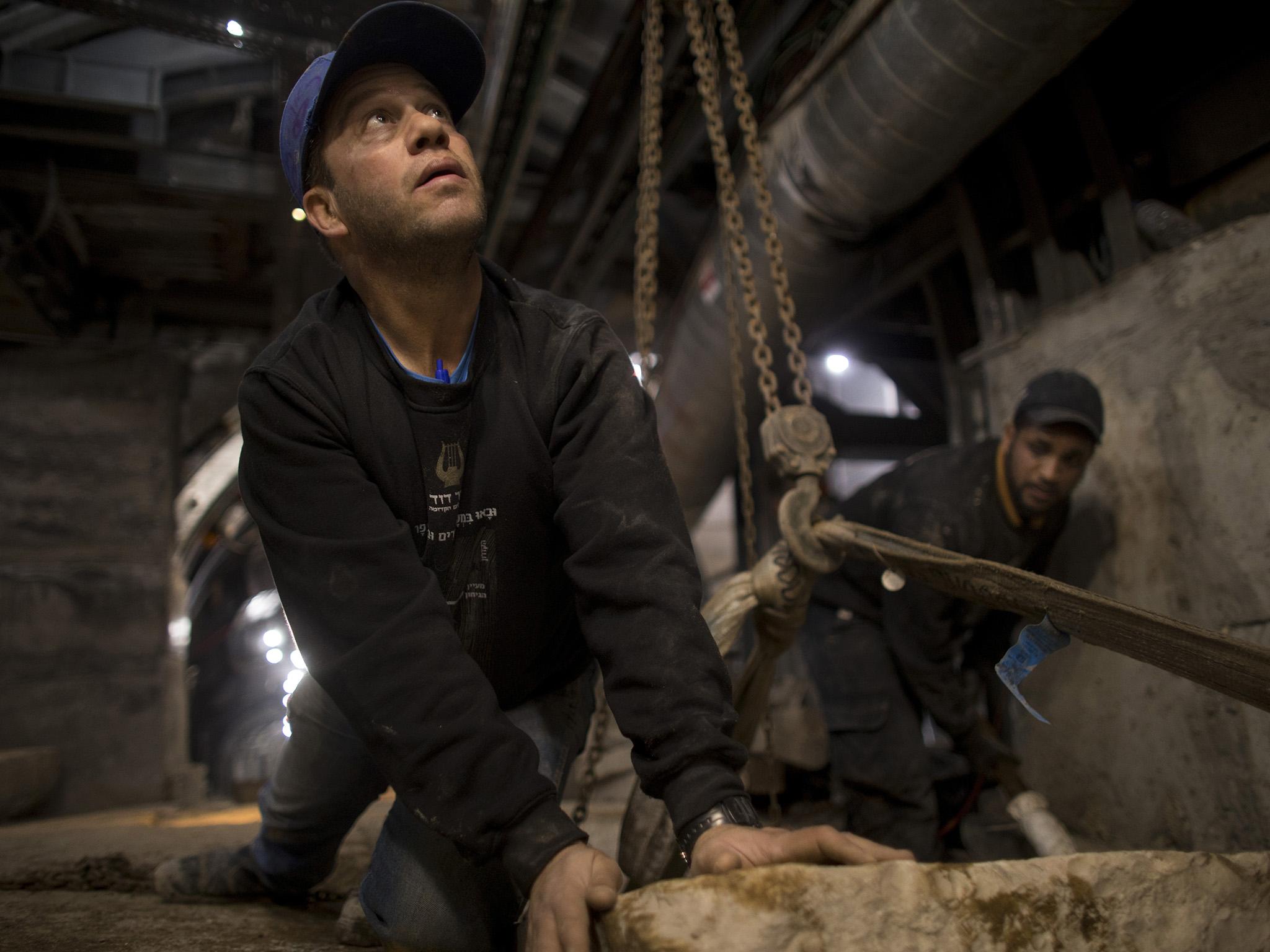 Israeli volunteers return a stone from AD70 in the tunnel site last month