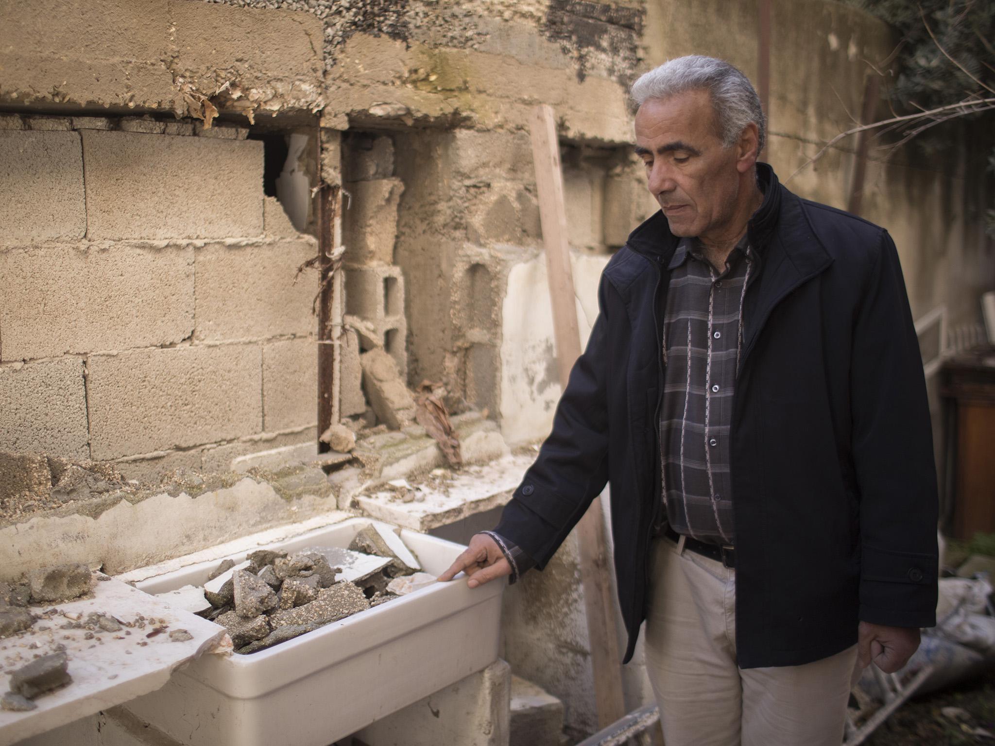 Wadi Hilweh resident Arafat Hamdan shows damage he says is caused by excavation