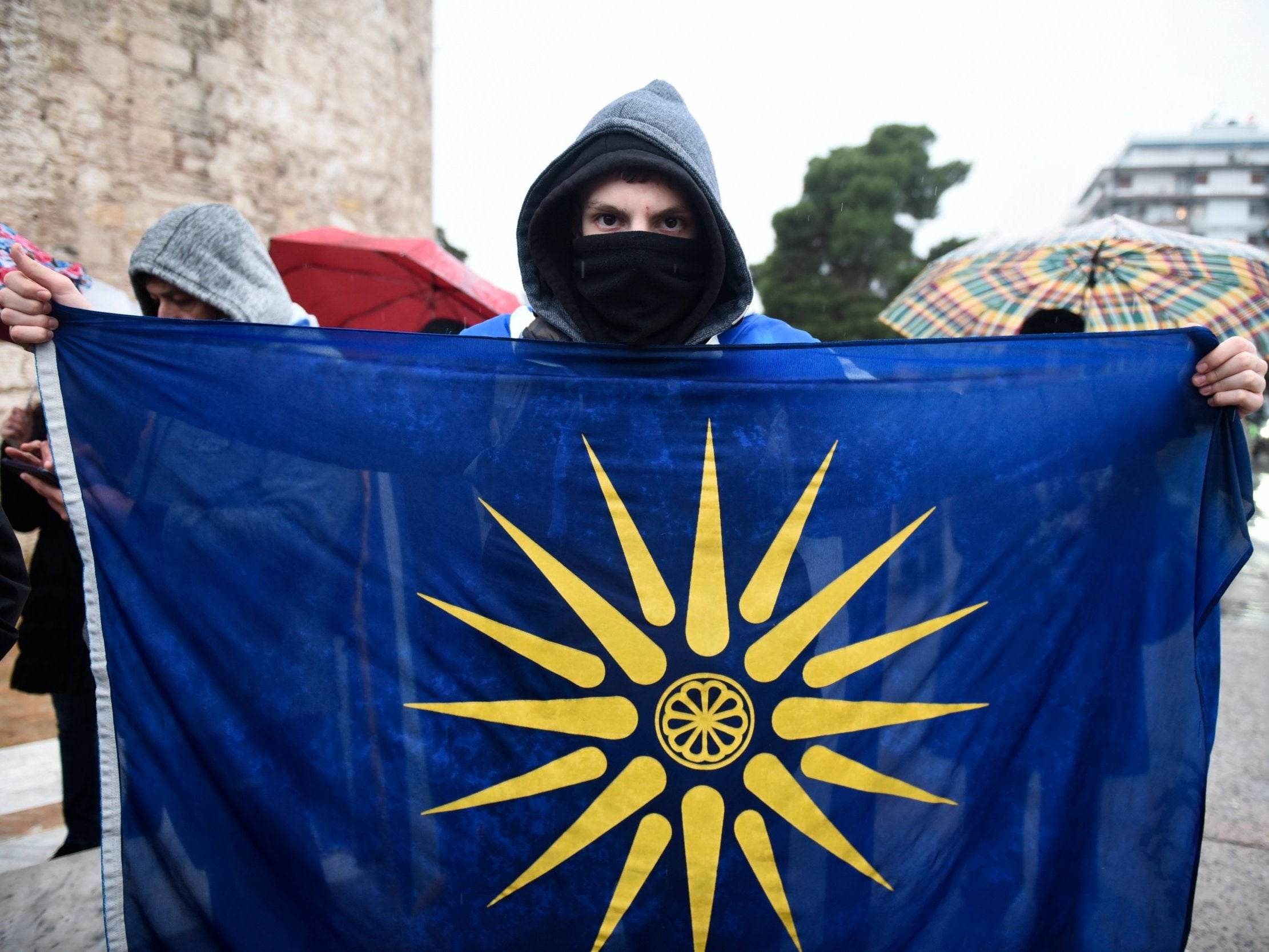 An opponent of the Macedonia agreement holds a flag with the Star of Vergina, the emblem of the ancient Greek kingdom of Macedonia and Alexander the Great