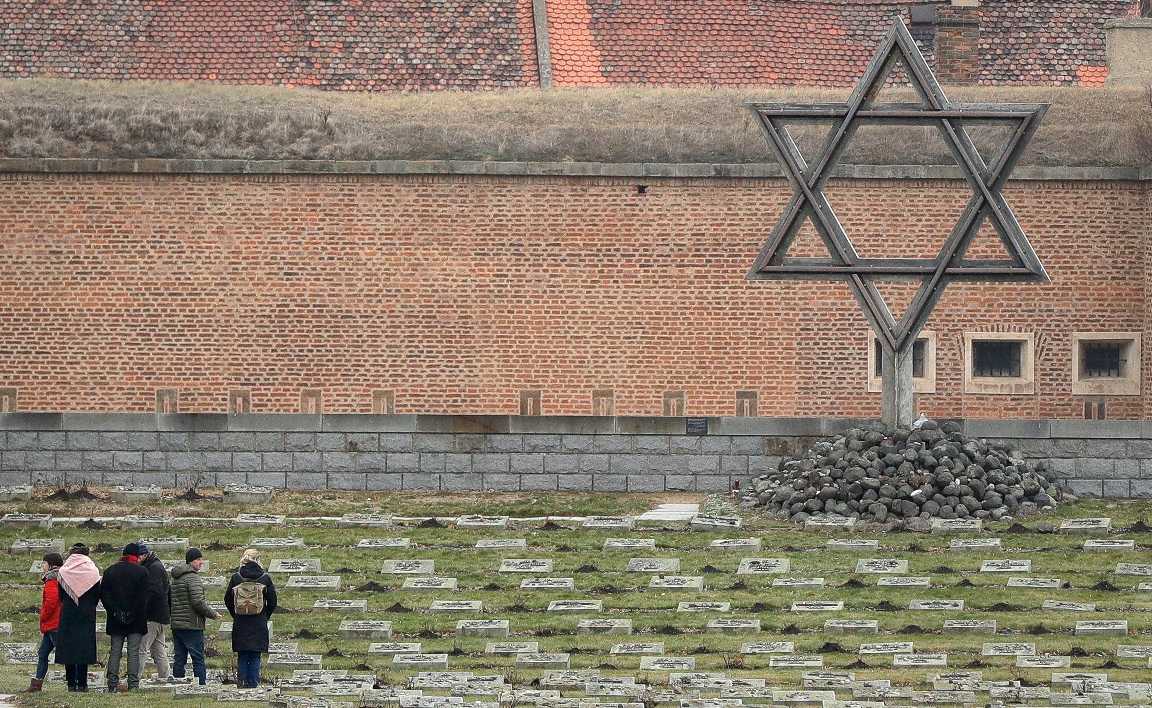 Visitors walk past a memorial at the former Nazi concentration camp in Terezin, Czech Republic