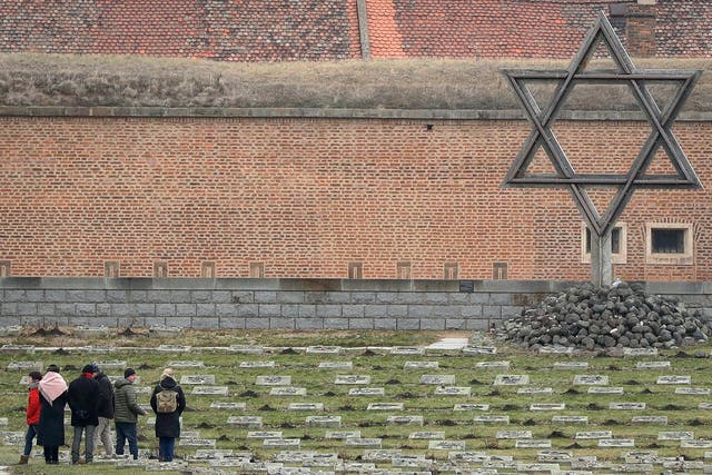 Visitors walk past a memorial at the former Nazi concentration camp in Terezin, Czech Republic