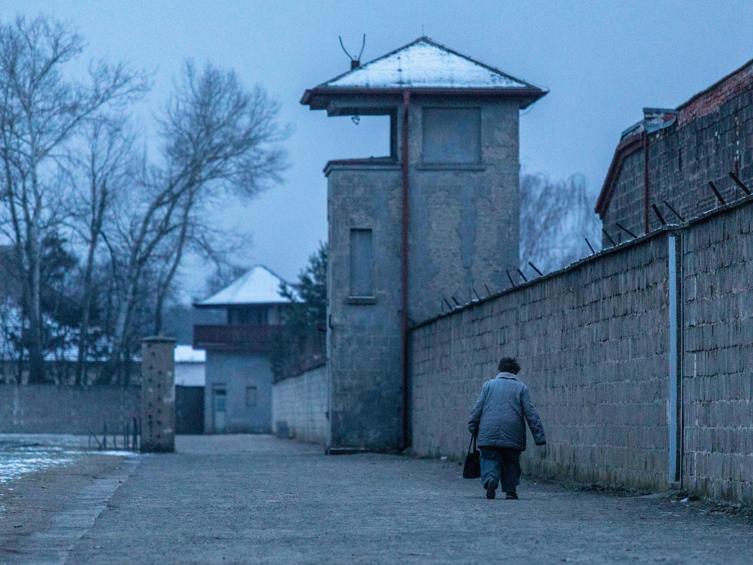 A visitor walks past a watch tower at the Sachsenhausen concentration camp memorial