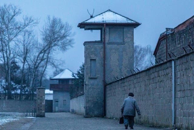 A visitor walks past a watch tower at the Sachsenhausen concentration camp memorial