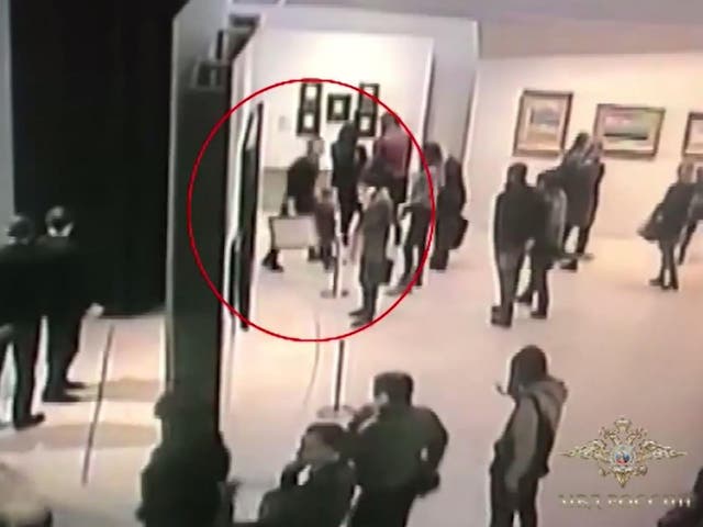A screenshot from CCTV footage showing the man calming stealing the painting in front of dozens of onlookers