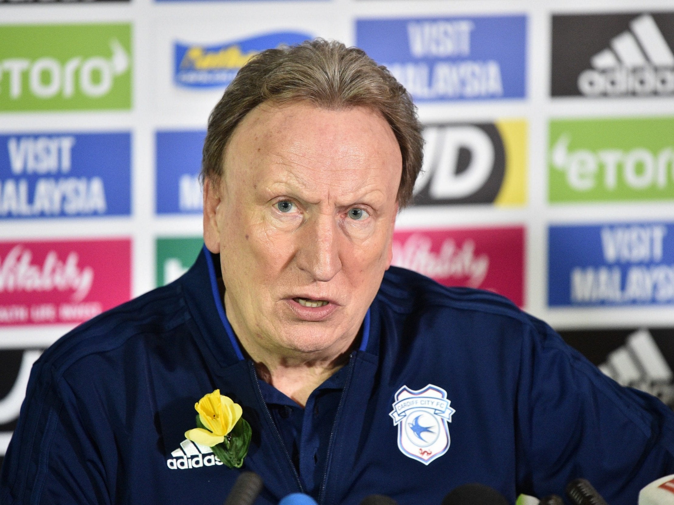 Warnock wore a yellow daffodil on his shirt during the press conference