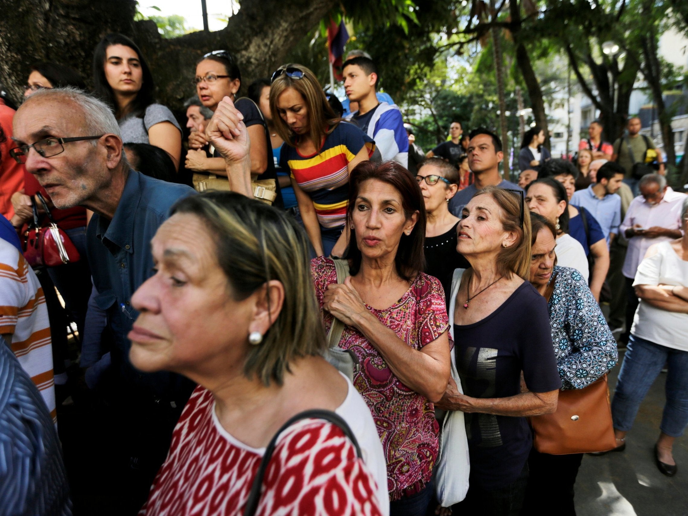 People try to listen to Juan Guaido as he speaks after attending mass on Sunday