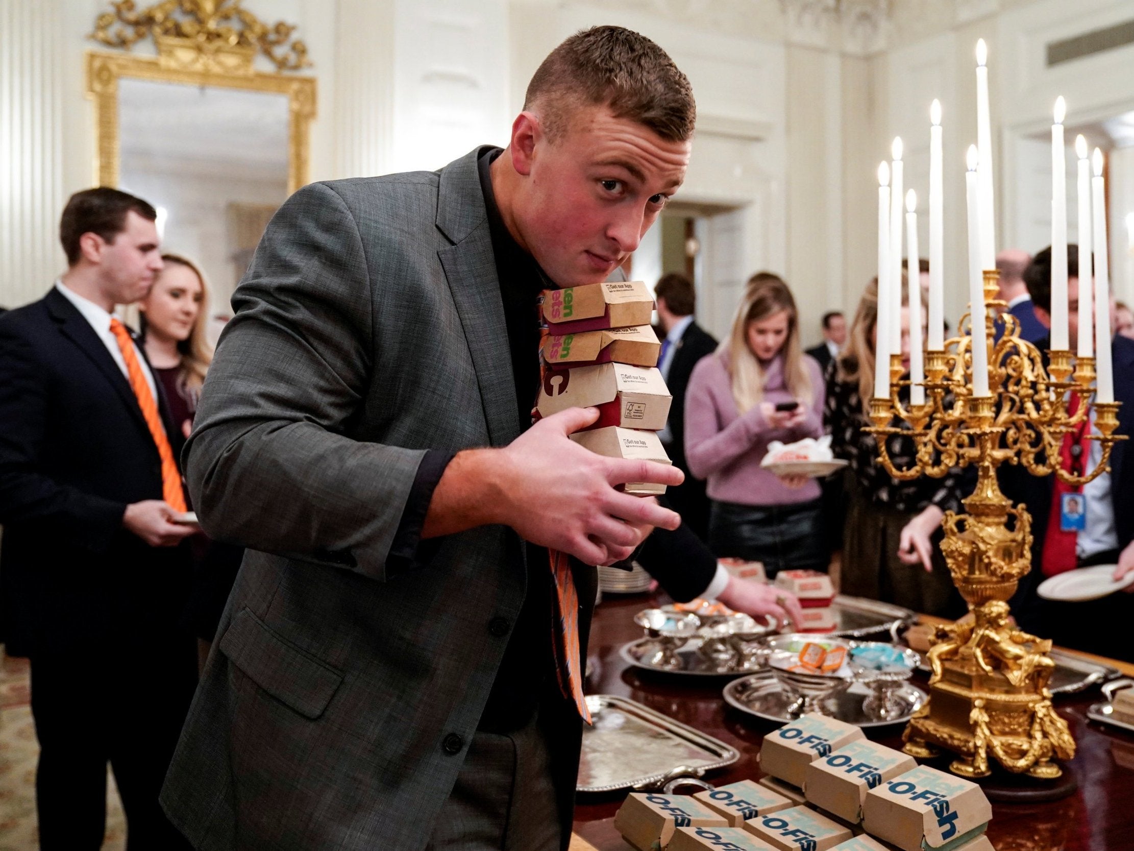 A Clemson player carries fast food hamburgers provided due to the partial government shutdown