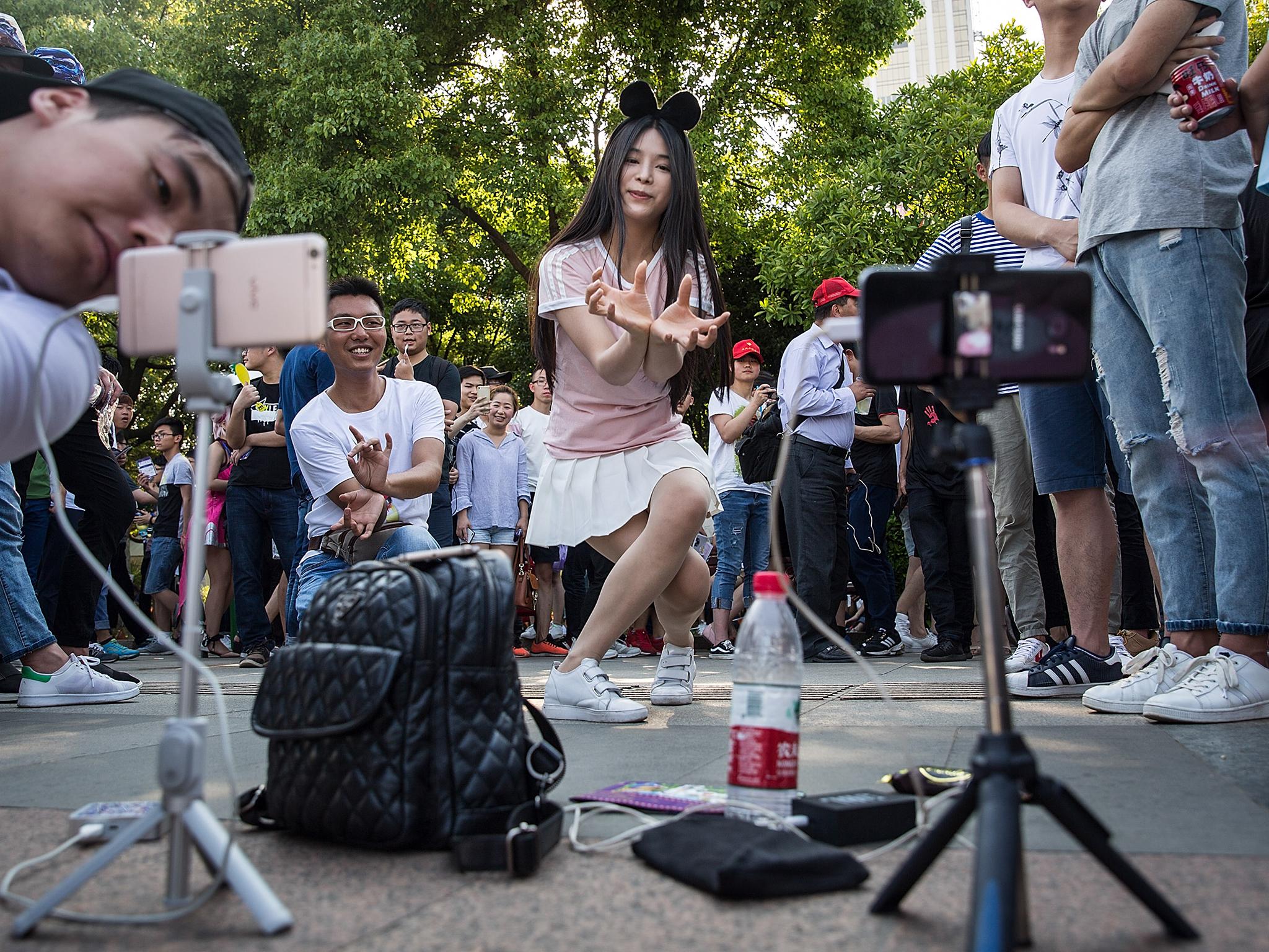 A presenter uses a smartphone to make a live webcast in Wuhan