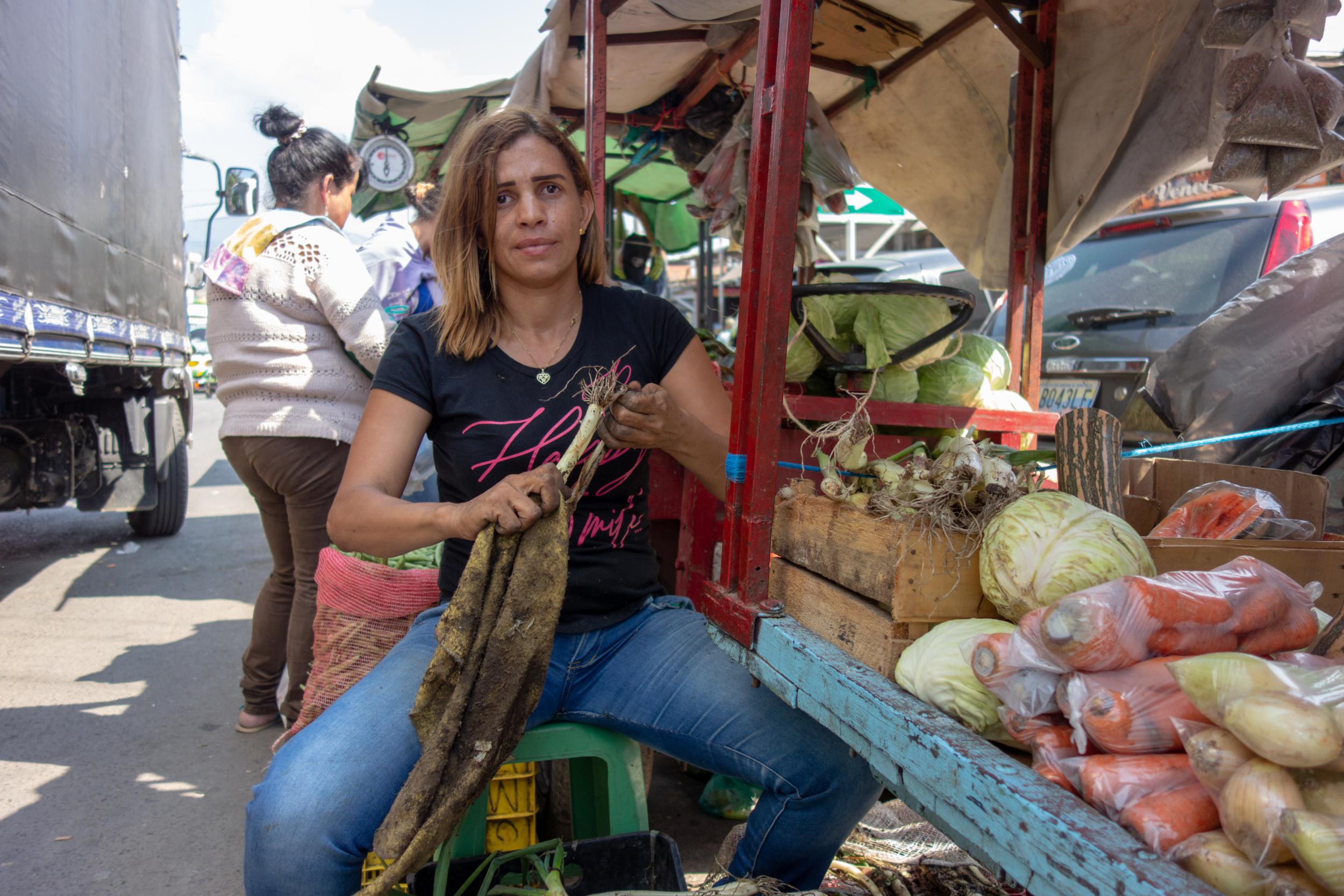 Marielis sells fruits and veg at the border to send money back home