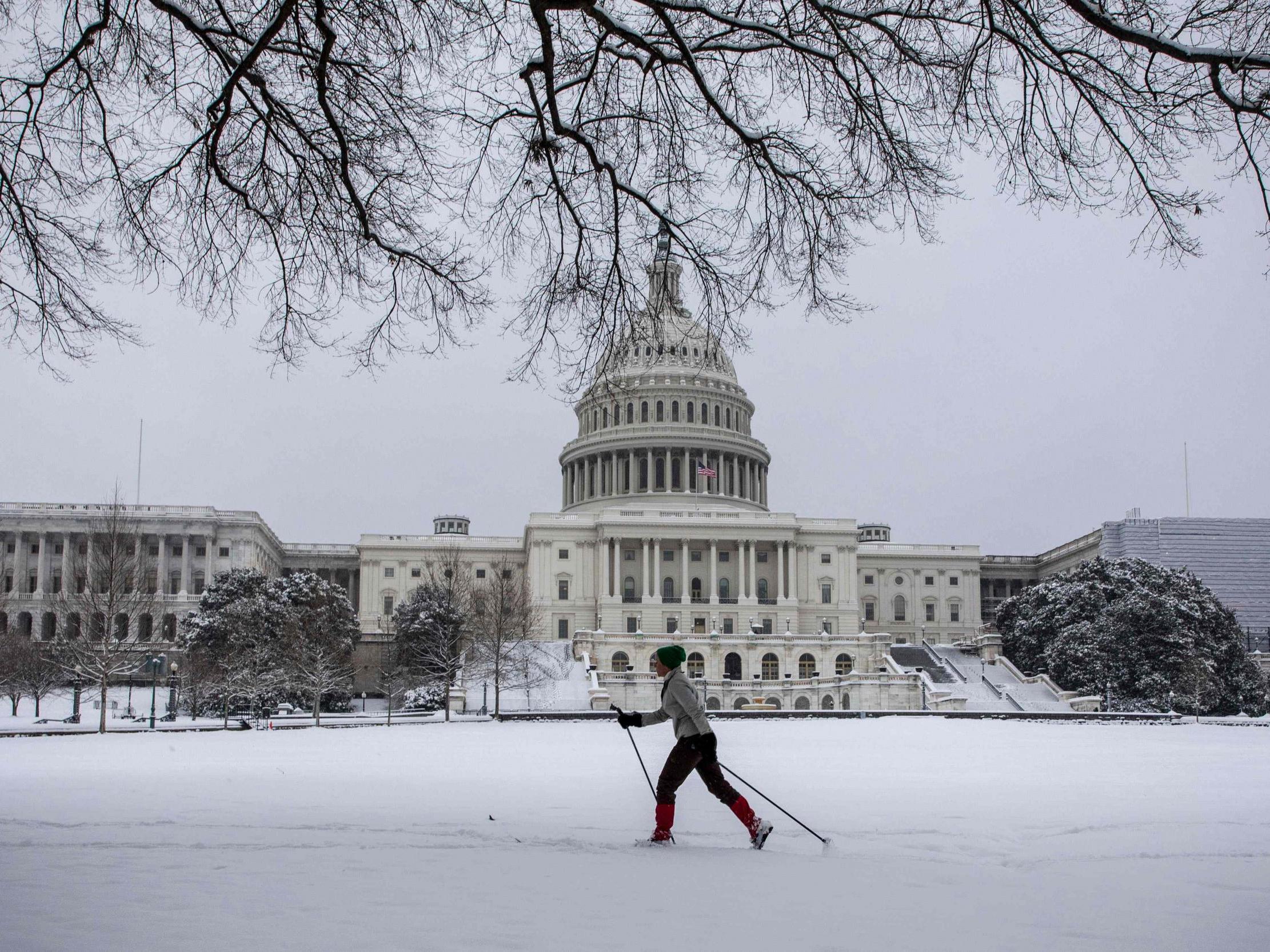 A woman cross country skis in front of the US Capitol as snow continues to fall in Washington, DC
