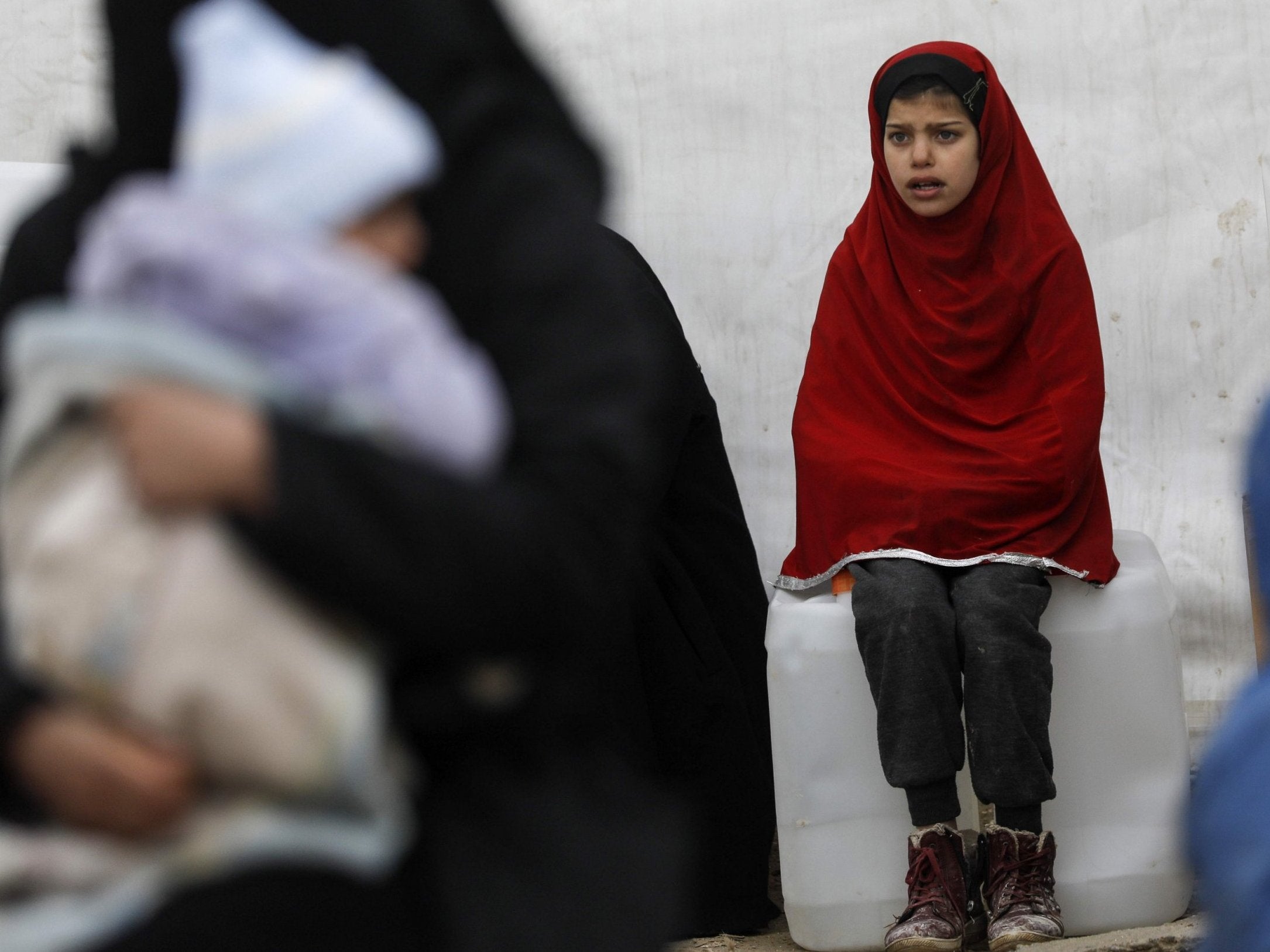 A Syrian girl looks on as aid items are delivered to the al-Hol camp, where hundreds of European women and children suspected of Isis links are being held