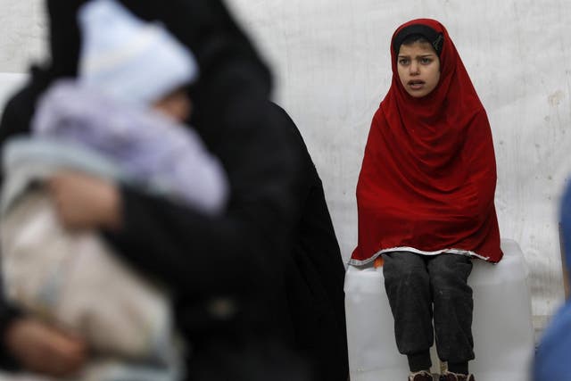 A Syrian girls looks on as aid items to cope with the winter weather are delivered to the al-Hol refugee camp, where hundreds of European women and children who are suspected of Isis links are being held.