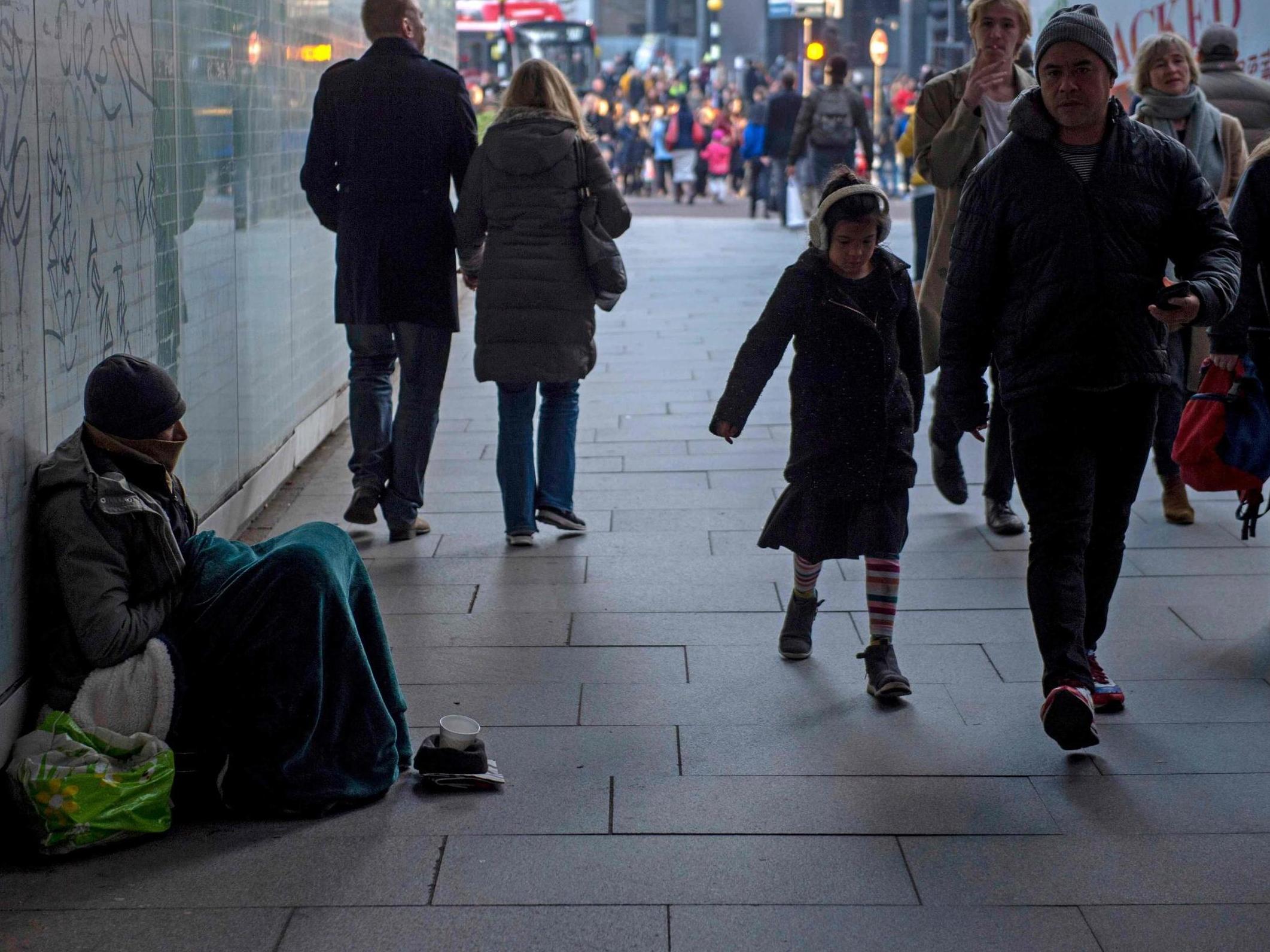 A homeless man sits in an underpass