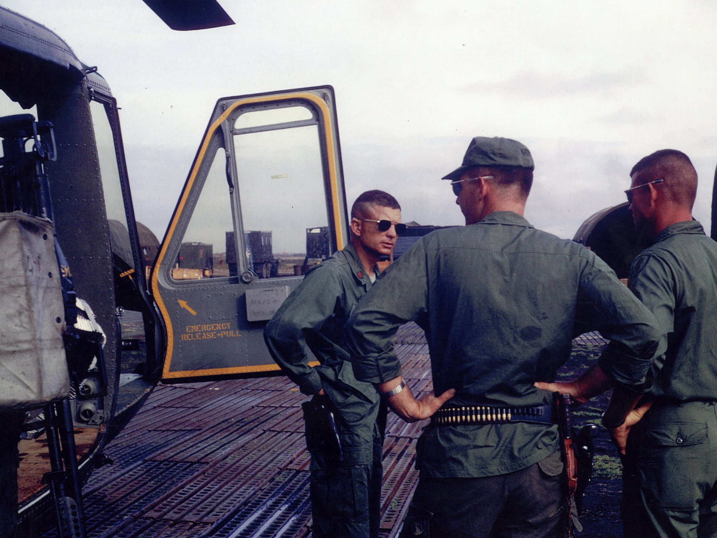 Kettles (left) beside his damaged Huey helicopter on return from the May 1967 rescue operation. He was credited with saving the lives of 44 men