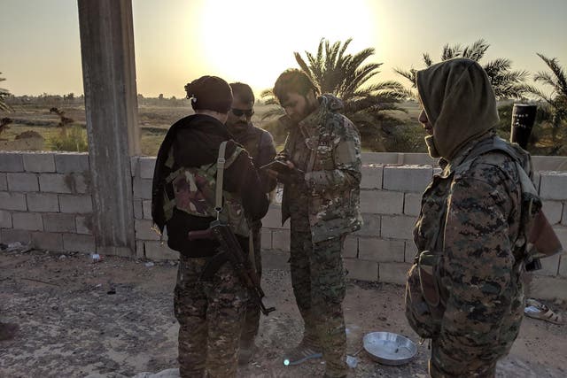 SDF fighters gather near the frontline against Isis in the village of Baghouz Tahtani, eaastern Syria.