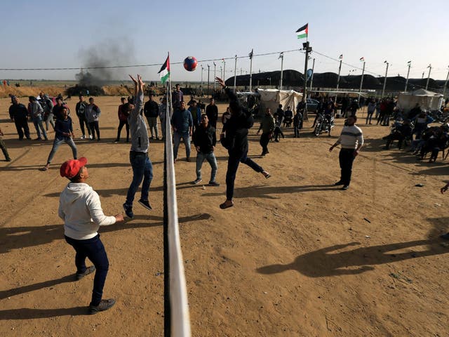 Palestinians play volleyball during a protest near the Israel-Gaza border fence today