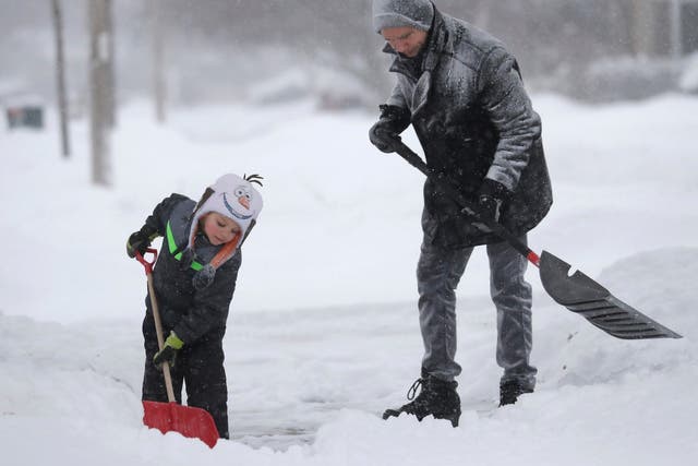 A father and son shovel snow from their driveway in Wisconsin