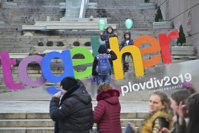 People walk past a sign "Together" in the town of Plovdiv, ahead of the opening ceremony of Plovdiv as one of European Capital of Culture under the motto "Together", Bulgaria, 12 January