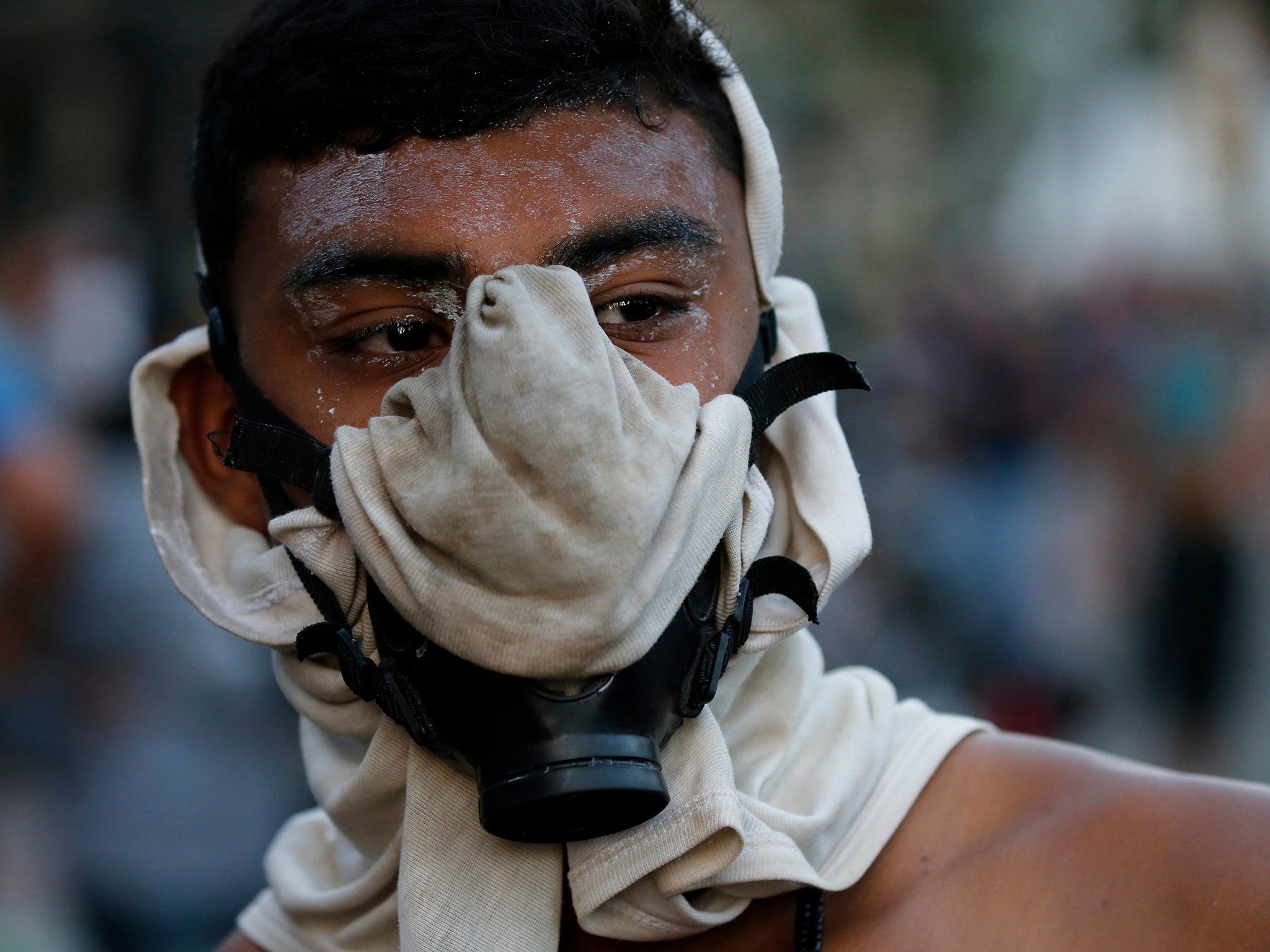 A protester wears a makeshift gas mask to protect from teargas during a protest on 23 January 2019