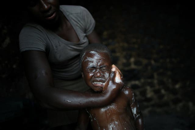 A man bathes his son at the family home