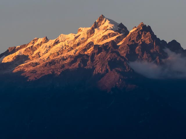 Sunlight illuminating the rugged peaks of the Kangchenjunga Mountain Range, a part of the Great Himalaya Range Sikkim, India