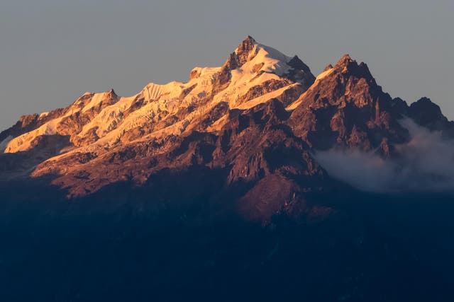 Sunlight illuminating the rugged peaks of the Kangchenjunga Mountain Range, a part of the Great Himalaya Range Sikkim, India