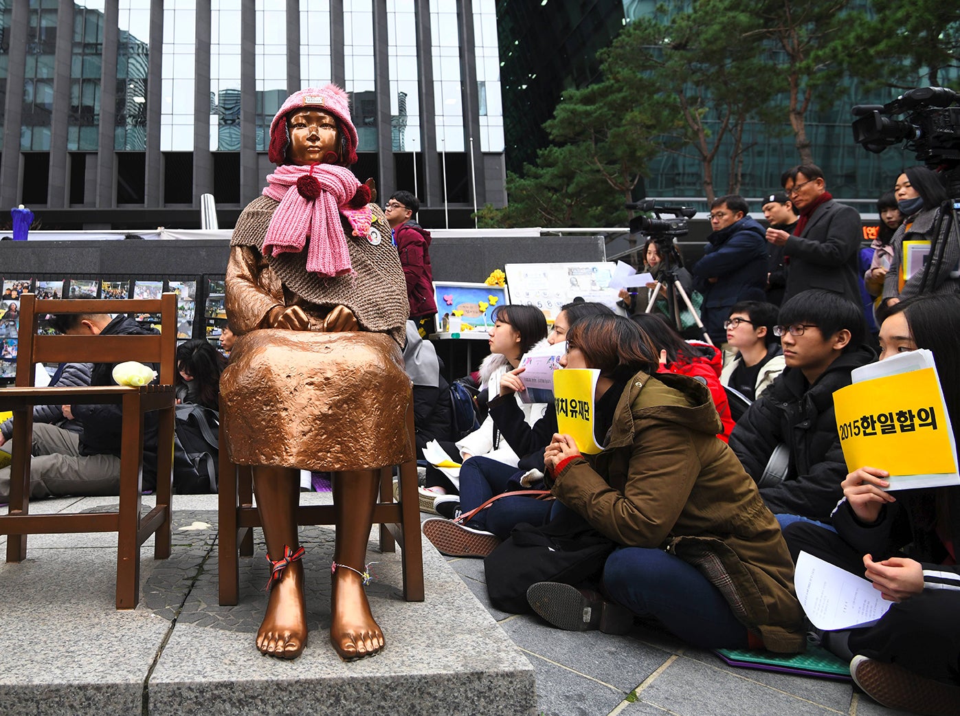 Protesters sit near a statue of a teenage girl symbolising ‘comfort women’
