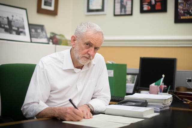 Labour leader Jeremy Corbyn signs a letter he has written to Prime Minister Theresa May